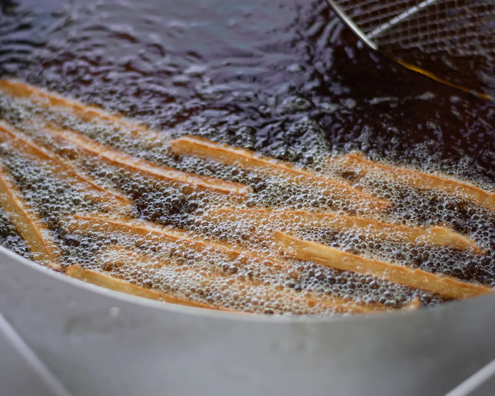 Hot fryer oil in a commercial kitchen, where a trap's grease load starts