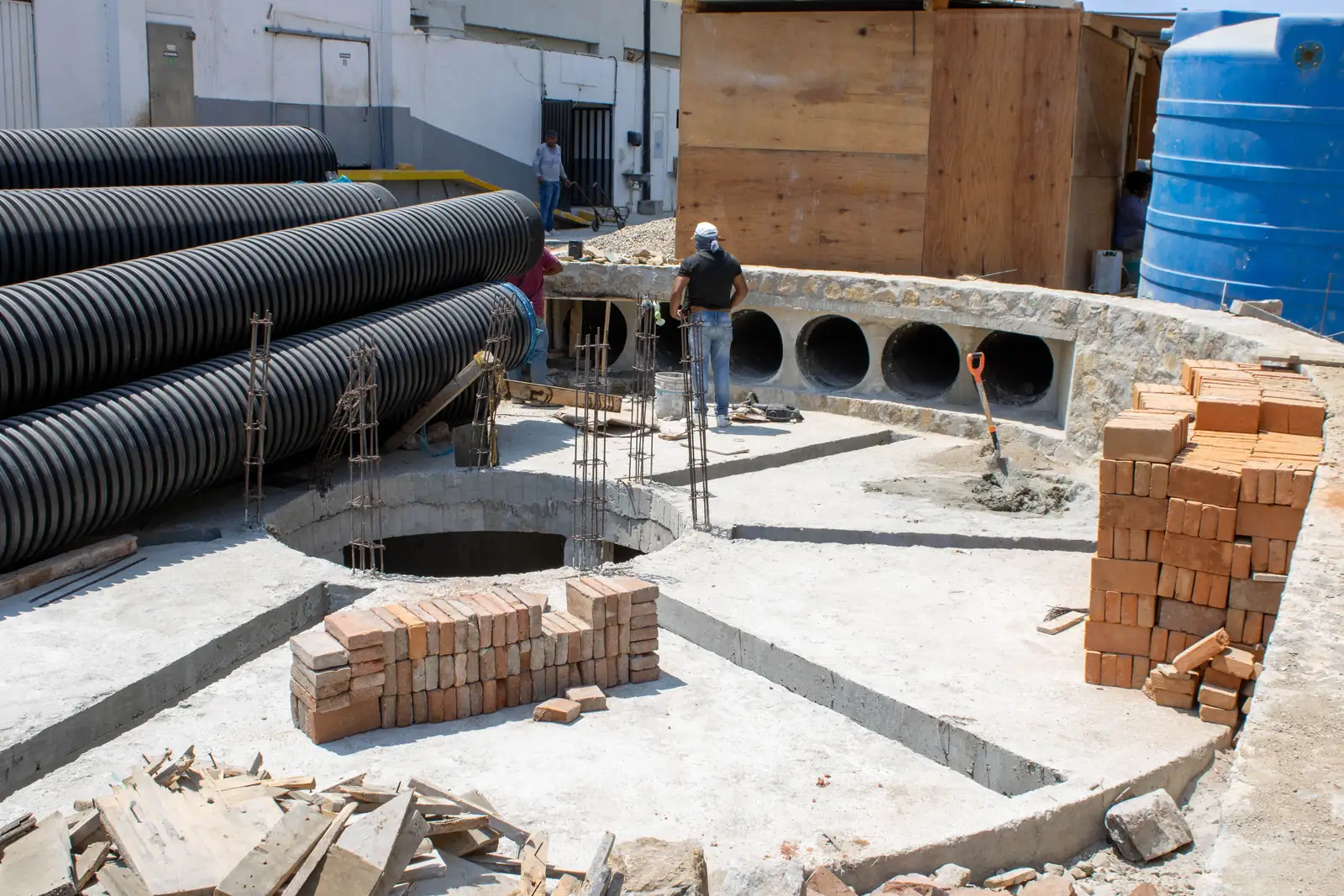 Large diameter pipe stacked beside a chamber under construction